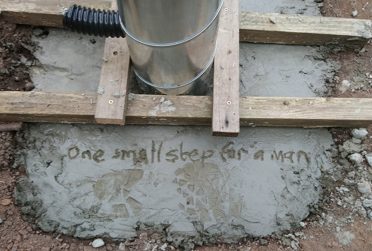 One small step etched in concrete at base of pier